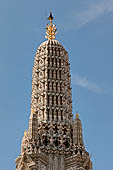 Bangkok Wat Arun - Detail of the spire of the Phra Prang with the golden crown at the peak. 